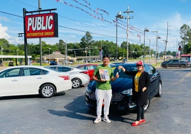 New owner purchasing new car at Public Auto Group.